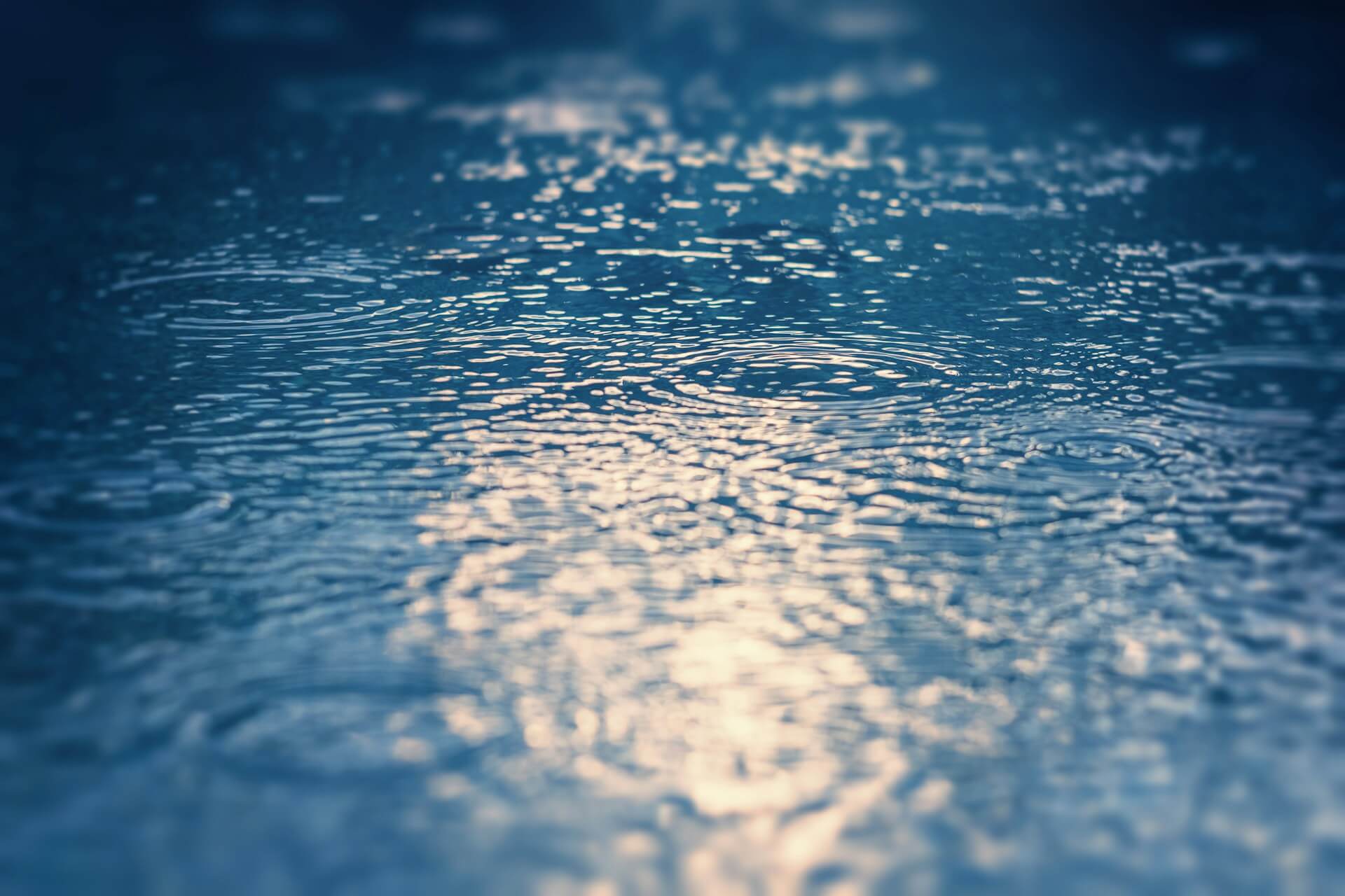 Foto detalhada de gotas de chuva em poças na rua